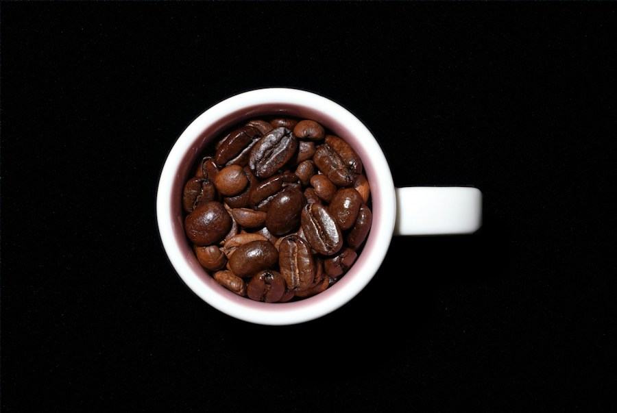 Roasted coffee beans in a cup against a dark background